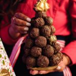 woman hands holding chocolate balls in christmas tree shape